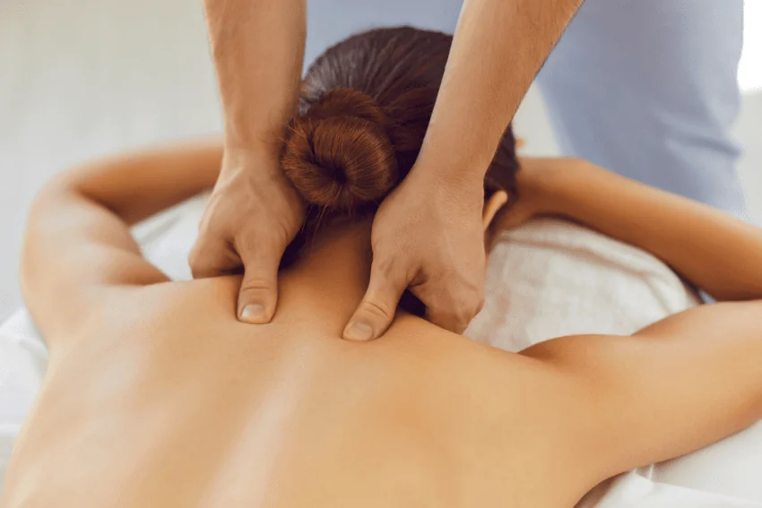 Massage therapist applying thumb pressure during massage therapy treatment